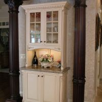 Close-up of two of the four solid cherry columns flanking custom furniture pieces by Wood-Mode.