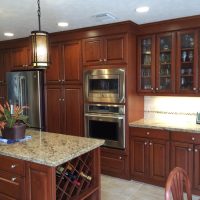 Cherry custom cabinetry by Wood-Mode (tm) with granite countertops anchor this highly functional and efficient kitchen. This gorgeous kitchen is illuminated by beautiful high-end pendant lights, along with high-efficiency LED under-cabinet lights and recessed cans.