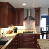 Cherry custom cabinetry by Wood-Mode (tm) with granite countertops anchor this highly functional and efficient kitchen. This gorgeous kitchen is illuminated by beautiful high-end pendant lights, along with high-efficiency LED under-cabinet lights and recessed cans.