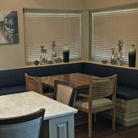 This custom banquette offers comfortable, convenient, attractive kitchen seating with custom blue leather cushions that bring out the blues in the Montgomery countertops.