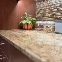 Crisp clean lines and warm colors come alive with the stunning LED color light display up in the skylight. The colors up in the skylight are ever-changing from one soft color to another. Brookhaven custom cabinets by Wood-Mode offer an abundance of storage amenities and sleek contemporary styling. The rich stained maple cabinet doors with aluminum edge-banding offer a unique option to ordinary slab doors & drawers. LED can lights and LED under-cabinet strips illuminate the kitchen, and clean, clutter-free backsplashes are made possible with the use of angled power strips below the upper cabinets.