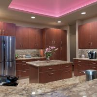Crisp clean lines and warm colors come alive with the stunning LED multi-color light display up in the skylight. The colors up in the skylight are ever-changing from one soft color to another. Brookhaven custom cabinets by Wood-Mode offer an abundance of storage amenities and sleek contemporary styling. The rich stained maple cabinet doors with aluminum edge-banding offer a unique option to ordinary slab doors & drawers. LED can lights and LED under-cabinet strips illuminate the kitchen, and clean, clutter-free backsplashes are made possible with the use of angled power strips below the upper cabinets.