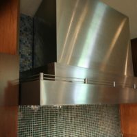 This custom stainless steel hood was built by Vent-A-Hood with a special sloped top section to fit to the sloped ceiling.
