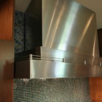 This custom stainless steel hood was built by Vent-A-Hood with a special sloped top section to fit to the sloped ceiling.