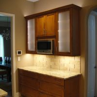 The Butler's Pantry boasts a built-in microwave, frosted glass doors with LED lighting inside the cabinets, and large drawers for storage of serving pieces, dishes and silverware.