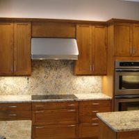 Lots of drawers provide ample storage for pots, pans and utensils, and vertical dividers behind the doors above the double ovens provides easy storage and access to cookie sheets, cake pans and serving platters. Note that there are no visible electrical outlets in the backsplash- they are concealed below the upper cabinets using angled power strips.