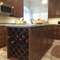 This spacious island has lots of storage (drawers on the other side), and a wine rack. The beautiful tile & stone backsplashes are uninterrupted by electrical outlets (custom power strips can be seen below the upper cabinets, and also on the back of this island).