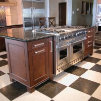 This transitional kitchen blends old with new and light with dark wood finishes, and features high-end Wood-Mode custom cabinetry with furniture detailing, and high-end stainless steel appliances.