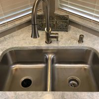 This low-divide sink is the perfect solution to soaking larger roasting pans, oven grates and other large items. The Cambria Montgomery quartz countertops offers subtle whispers of soft blues and grays in a white background.