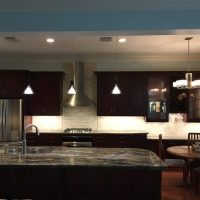 We removed this major wall that used to divide the kitchen from the Family Room, providing our clients with an amazing open concept kitchen, as well as additional seating at the counter. Note that there are no unsightly outlets or switches in these beautiful backsplashes; all the outlets are cleverly concealed below the upper cabinets. Gorgeous Fusion quartzite countertops add excitement to the dramatic dark cherry cabinets.