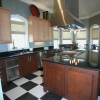 This transitional kitchen blends old with new and light with dark wood finishes, and features high-end Wood-Mode custom cabinetry with furniture detailing, and high-end stainless steel appliances.