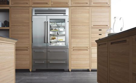 Stainless-steel built-in Sub-Zero refrigerator integrated in modern wood kitchen.